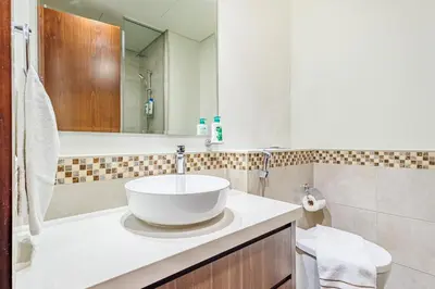 a white bathroom with a sink and a mirror at Stylish 2 BR Business Bay - Canal View - Gym and Pool in Dubai