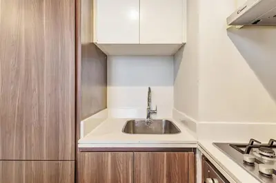 a small kitchen with a sink and a stove at Stylish 2 BR Business Bay - Canal View - Gym and Pool in Dubai