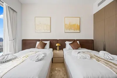 two beds sitting next to each other in a bedroom at Burj Khalifa and Dubai Fountian Direct View - Luxury 2BR Flat - Downtown Dubai in Dubai