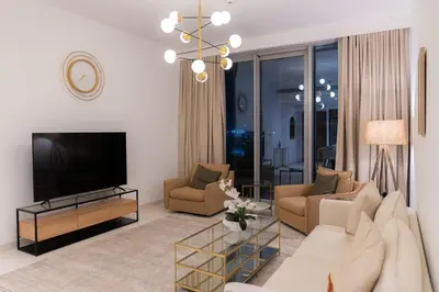 a living room with a couch and a television at Seaside Bliss Chic 1BR with Balcony, Pool & Gym in Dubai