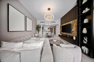 a living room with a white couch and a tv at Burj View Chic 2BR Downtown Dubai in Dubai