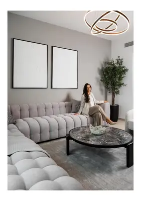 a woman sitting on a couch in a living room at Burj View Chic 2BR Downtown Dubai in Dubai