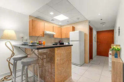 a kitchen with a counter and a refrigerator at Stylish 1BR - Pool, Gym Access & City Skyline Views near JBR Beach in Dubai
