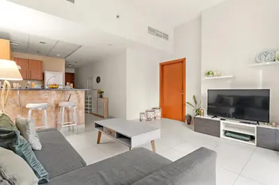 a living room with a couch and a table at Stylish 1BR - Pool, Gym Access & City Skyline Views near JBR Beach in Dubai