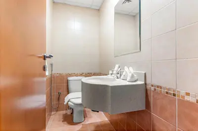 a bathroom with a sink and a toilet at Stylish 1BR - Pool, Gym Access & City Skyline Views near JBR Beach in Dubai