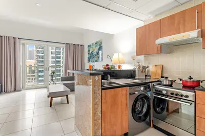 a kitchen with a stove and a dishwasher at Stylish 1BR - Pool, Gym Access & City Skyline Views near JBR Beach in Dubai