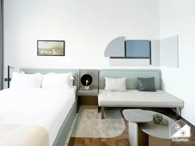 a bedroom with a bed and a desk and a table at Luxury Studio in MAG City l Private Balcony in Dubai