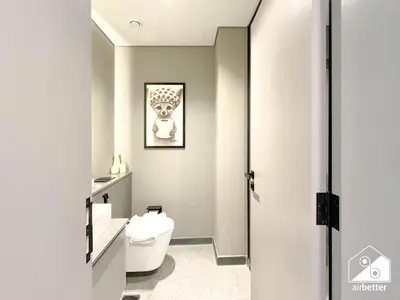 a bathroom with a toilet and a picture on the wall at Luxury Studio in MAG City l Private Balcony in Dubai