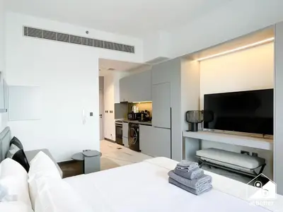 a living room with a white couch and a flat screen tv at Luxury Studio in MAG City l Private Balcony in Dubai