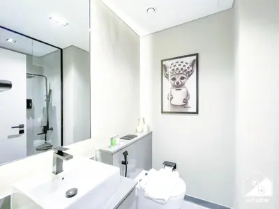 a bathroom with a sink and a toilet and a mirror at Modern Studio Retreat l MAG l Parking & WI-FI in Dubai