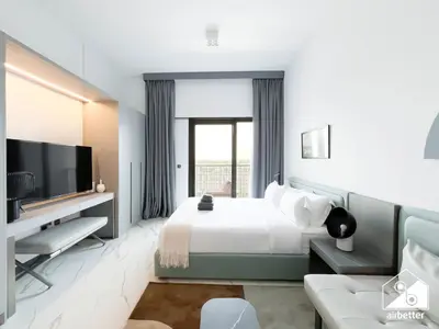 a hotel room with a bed and a tv at Modern Studio Retreat l MAG l Parking & WI-FI in Dubai