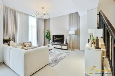 a living room with a white couch and a tv at Majestic 3BR Villa in DH2 by Deleguest in Dubai