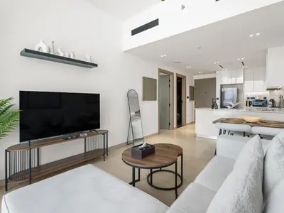 a living room with a couch and a tv at Chic and Stylish 1 BDR in Binghatti corner - JVC in Dubai