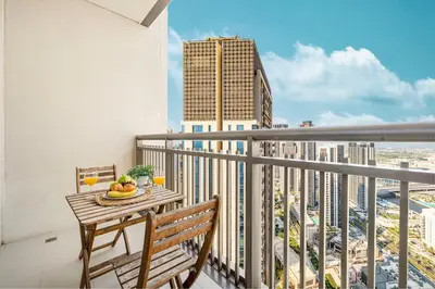 a balcony with a table with a bowl of fruit on it at Modern Creekside 1BR Near Dubai Mall & Downtown in Dubai