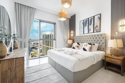 a bedroom with a large bed and a large window at Modern Creekside 1BR Near Dubai Mall & Downtown in Dubai
