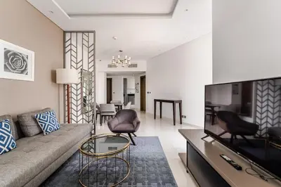 a living room with a couch and a tv at Stylish 1BR with Burj & Canal View in Dubai