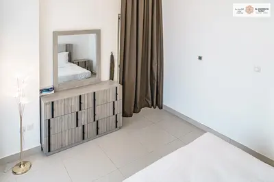 a bedroom with a mirror on a dresser at Serenity 1 bdr with private garden in Dubai