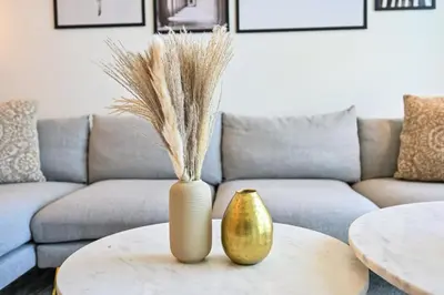 two vases sitting on a table in front of a couch at BEST Burj Khalifa View 2br 3 beds in Dubai