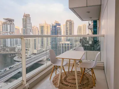 a table and chairs on a balcony with a view of the city at Superb 2BR Prime Locale between Dubai Marina JBR in Dubai