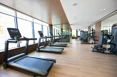 a row of treadmills in a gym with a row of treadms at Private Pool! Exceptional 2 Bedroom! Brand New Building with Pool and Gym! in Dubai