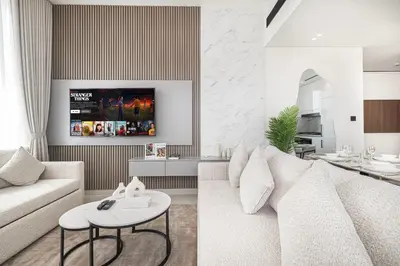 a living room with a white couch and a table at Private Pool! Exceptional 2 Bedroom! Brand New Building with Pool and Gym! in Dubai