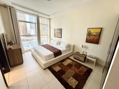 a bedroom with a bed and a large window at Space, Style & Sunshine 2bedroom in Dubai