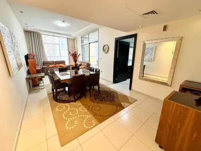 a dining room and living room with a table and chairs at Space, Style & Sunshine 2bedroom in Dubai
