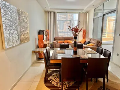 a dining room with a table and a couch at Space, Style & Sunshine 2bedroom in Dubai