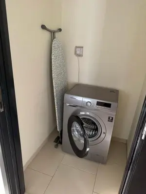 a washing machine in a room with a wall at Space, Style & Sunshine 2bedroom in Dubai