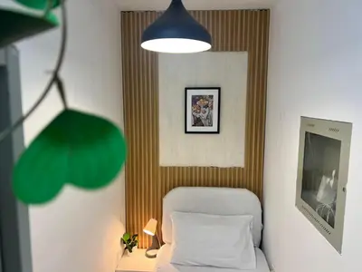 a small bedroom with a bed and a mirror at Elite Single Suite Room Partition In Tecom in Dubai