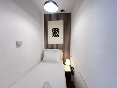 a small room with a bed and a picture on the wall at Deluxe solo Room In Barsha Heights Tecom in Dubai