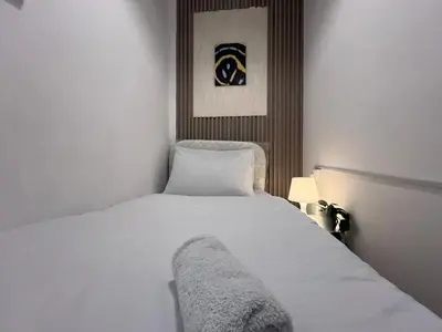 a bedroom with a white bed with a blanket on it at Deluxe solo Room In Barsha Heights Tecom in Dubai