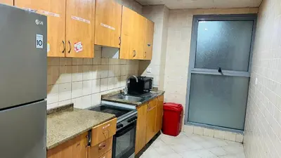 a small kitchen with a sink and a refrigerator at Comfort Nock Partition Room Near Mall Of emirates in Dubai