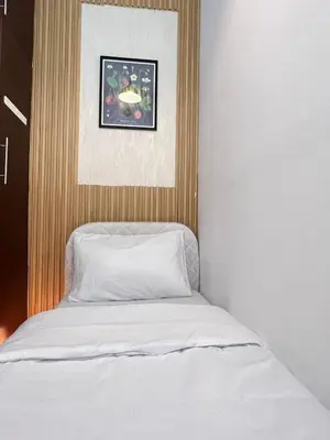 a bed with white sheets and a picture above it at Solo space Partition room In Barsha Heights Tecom in Dubai
