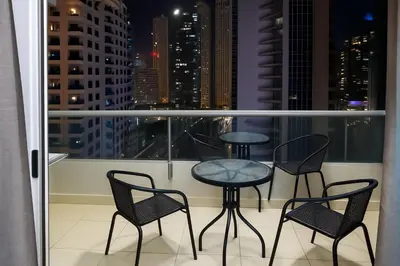 a balcony with three chairs and a table on a balcony at The S Royal Marina Boutique Stay For Ladies And Families Only in Dubai