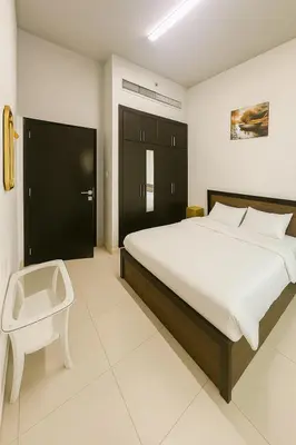 a bedroom with a bed and a chair in it at The S Royal Marina Boutique Stay For Ladies And Families Only in Dubai