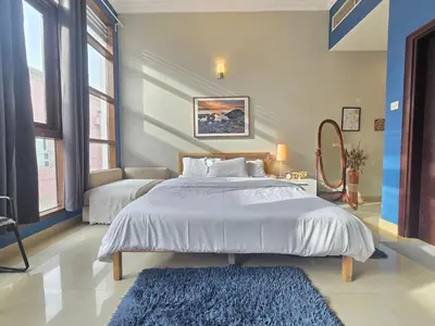 a bedroom with a large bed and a blue rug at Efficiancy studio 6mins walk to metro Near DWTC in Dubai