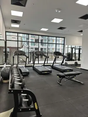 a gym with several treadmills and elliptical machines at LUXE - Luxury Studio - Modern and Cozy in Dubai