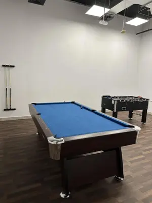 a ping pong table in a room with two tables at LUXE - Luxury Studio - Modern and Cozy in Dubai