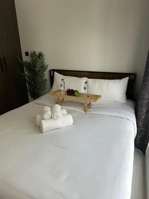 a white bed with towels and a tray on it at LUXE - Luxury Studio - Modern and Cozy in Dubai