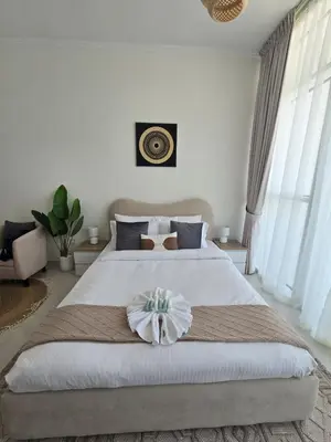a bedroom with a large bed with a flower on it at Modern DAMAC Hills Studio with Balcony, Gym & Pool in Dubai