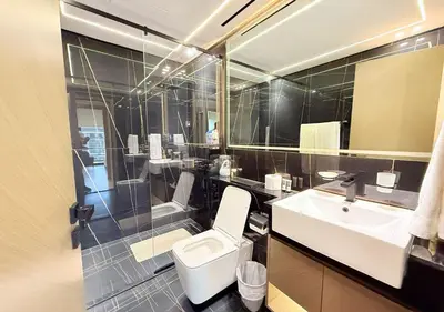 a bathroom with a white toilet and a sink at Binghatti Crescent Cozy 2 BR in Dubai