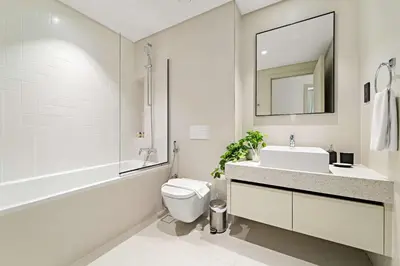 a bathroom with a sink and a toilet and a mirror at Silkhaus Seaside Bliss 1BDR in Marina Vista in Dubai