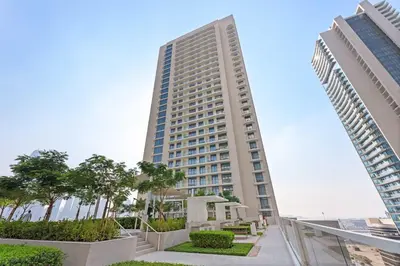 a tall building with trees in front of it at Silkhaus Seaside Bliss 1BDR in Marina Vista in Dubai