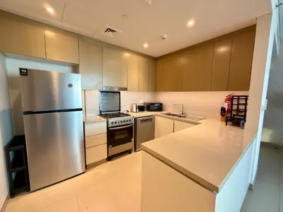 a kitchen with a stainless steel refrigerator and a sink at Sunset Sea View at 5242 Emaar in Dubai