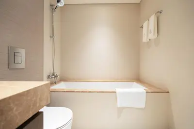 a bathroom with a toilet and a bath tub at KeyRock - Palm & Sea View Retreat with Pool Access in Dubai