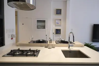 a kitchen counter with a sink and a stove at Beautiful Brand New Studio -Pool -Balcony -Parking in Dubai