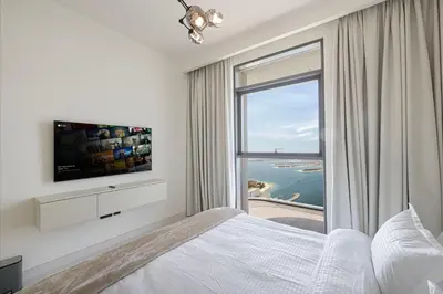 a bedroom with a bed and a large window at Luxury 3BR Palm Views at Emaar Beachfront in Dubai