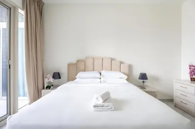 a bedroom with a large white bed with towels on it at GuestReady - High Floor | Canal View Near Dubai Marina in Dubai