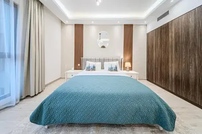 a bedroom with a large bed with a blue bedspread at Chic 2BD in Lamtara for 4, Madinat Jumeirah Living in Dubai